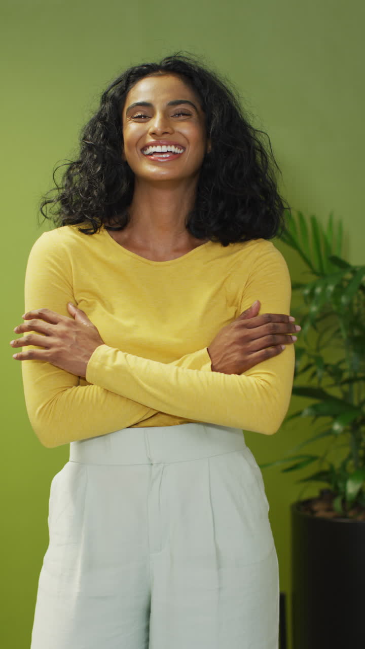 video vertical de una feliz mujer de negocios biracial en fondo verde