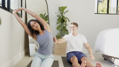 relaxing at home, young multiracial couple sitting on floor and smiling together