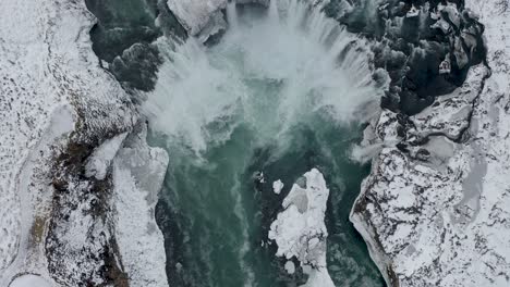 spectacular drone shot of mighty godafoss waterfall in north iceland during icy winter day- aerial tilt up shot