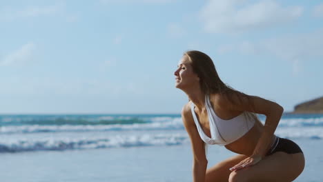 hermosa atleta con hermosos senos en pantalones cortos negros y una camiseta blanca se agacha y hace un salto. entrenamiento circular para el corazón. cámara de cámara lenta