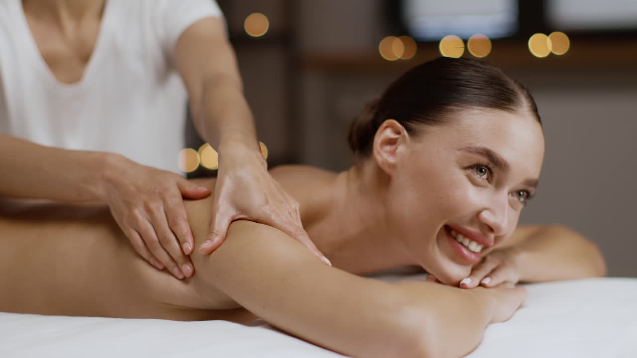 una mujer recibiendo un masaje de espalda en un spa.