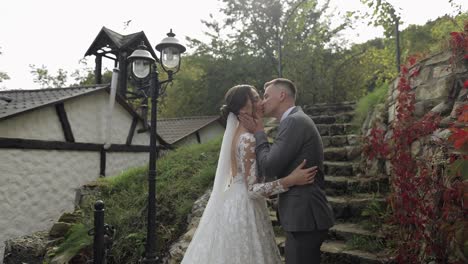 Lovely-newlyweds-caucasian-bride-embracing-groom-in-park-making-kiss,-wedding-couple-family-hugging