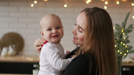 Young-Mother-Holding-her-Newborn-Child-slow-motion.-Family-at-home,-mom-and-baby-boy-for-christmas