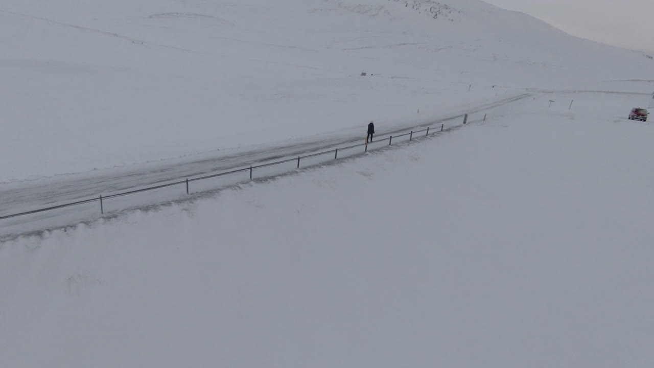 시골의 얼어붙은 길을 걷고 있는 소녀 주변의 궤도