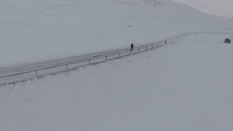 orbit view around girl walking on frozen road in countryside