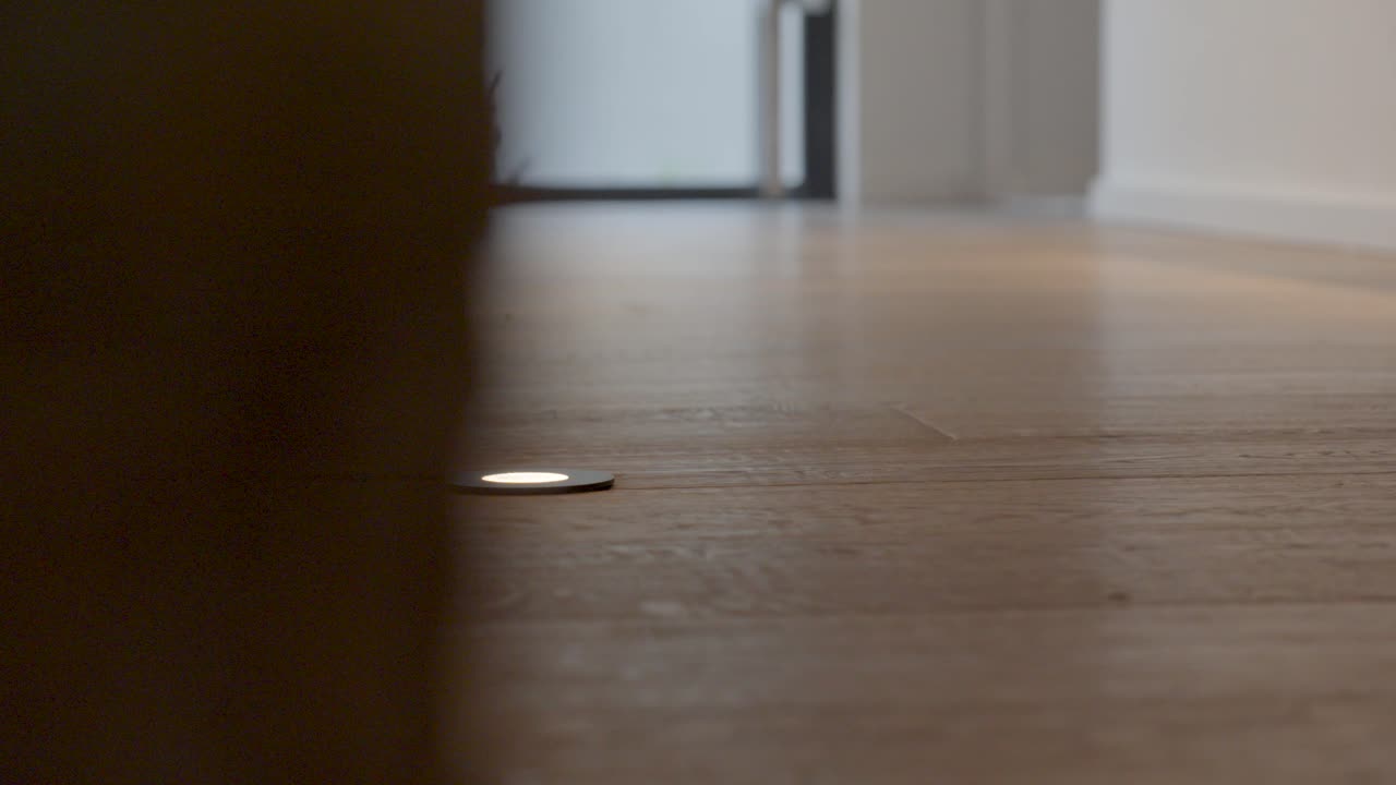 Slow motion revealing shot of led foot lighting along a wall within a villa