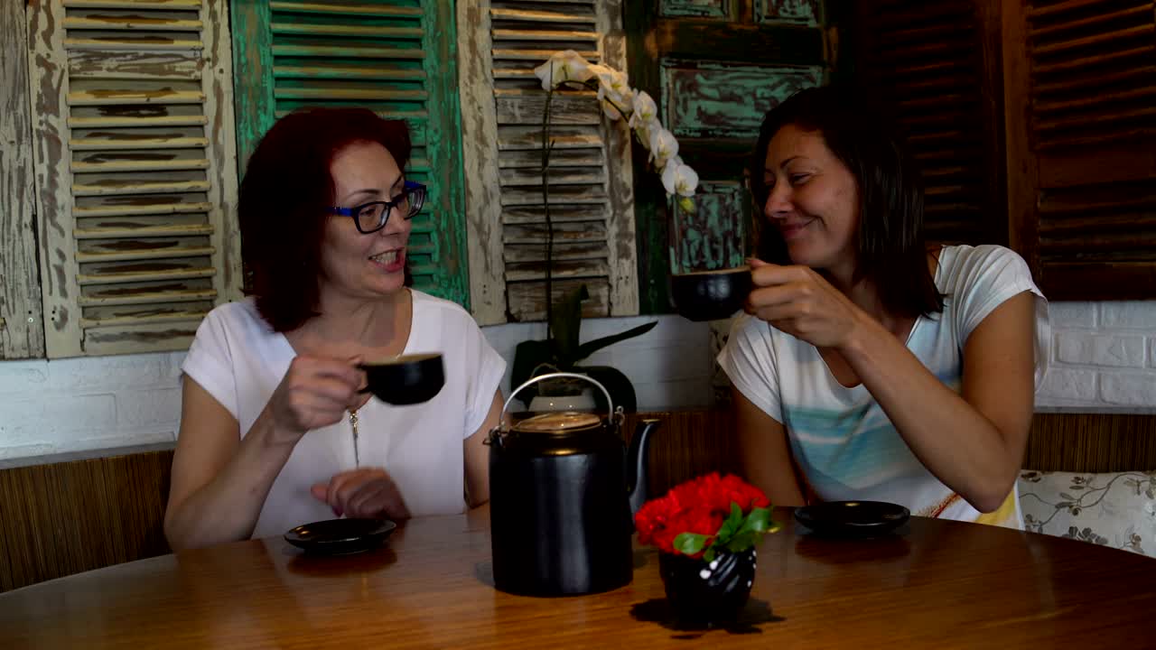 las mujeres en el restaurante hacen sonar las tazas y beben té.