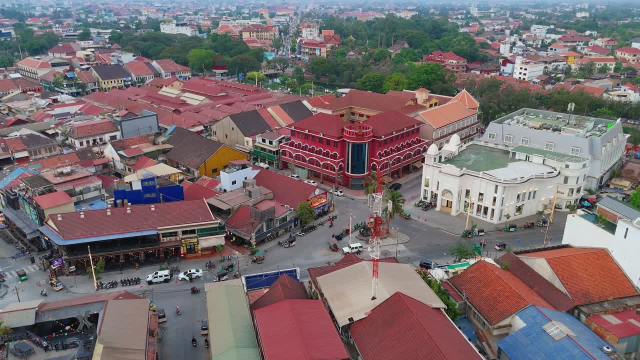 Video drone di sekitar Phnom Penh, Kamboja, menampilkan pemandangan kota yang ramai dengan atap-atap cerah, bangunan komersial, dan ruang hijau, menawarkan pemandangan udara dinamis dari lingkungan perkotaan