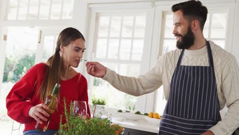 video de una feliz pareja caucásica cocinando y bebiendo vino