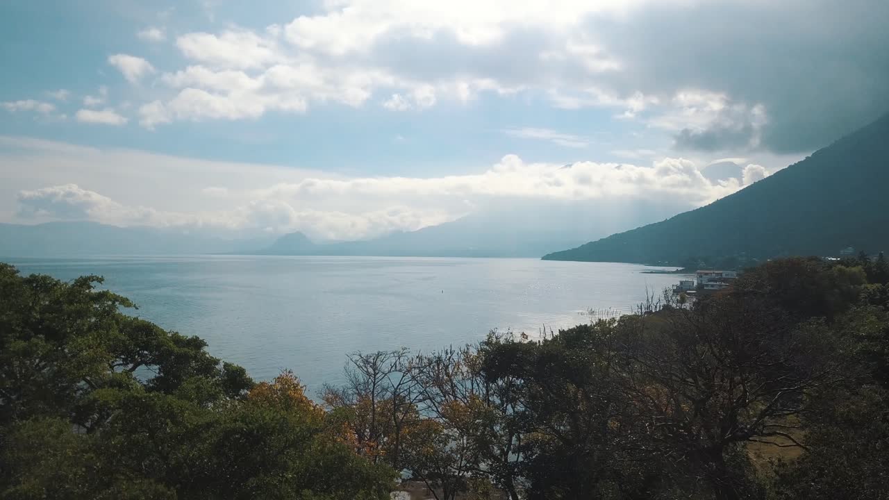 Drone terbang di atas pepohonan di hutan di Danau Atitlan, Guatemala.