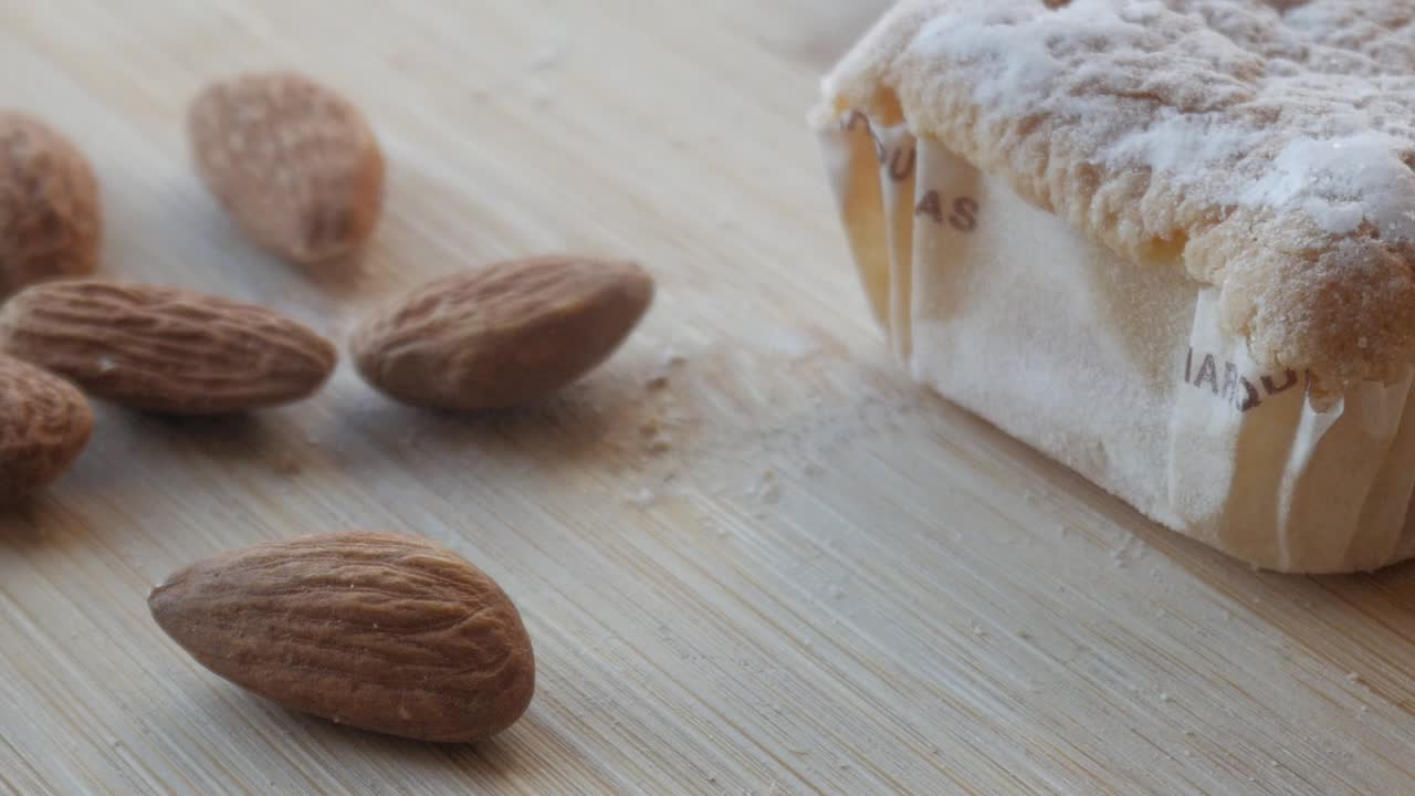 pastel dulce tradicional español de navidad con almendras en una superficie de madera, primer plano