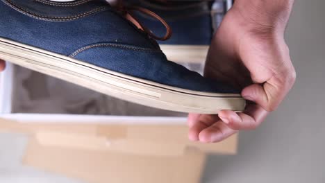 unboxing a pair of denim sneakers