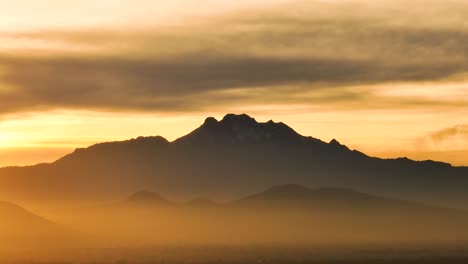 colorful shot of distant volcano in iztaccihuatl at sunrise, mexico city