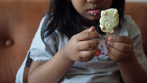 little girl enjoying a white chocolate popsicle