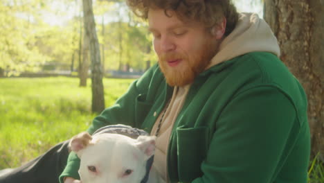 man and dog sharing playful and affectionate moments in a sunny park