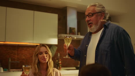 senior man making toast for family at table. happy family clicking glasses