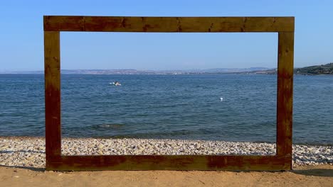 wooden frame on beach sea shore for location decoration of celebratory seaside events and boat in background