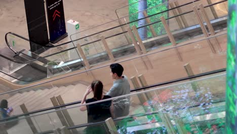 two people riding down an escalator together