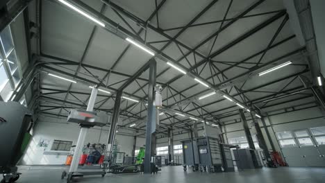 spacious automotive workshop with vehicle lifts, tools, workstations, and mechanics working. bright industrial space designed for car repair and maintenance