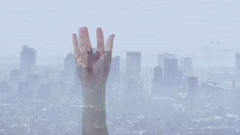 reaching upward, hand against cityscape with hazy urban animation in background