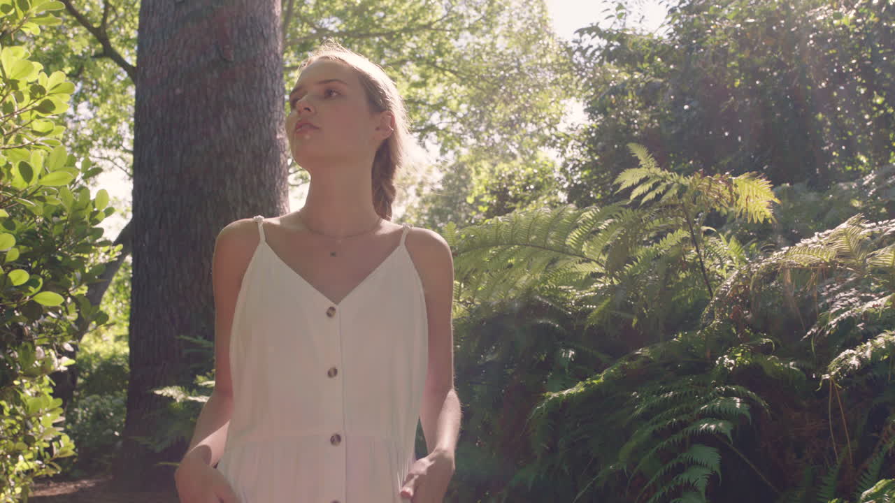 chica de la naturaleza caminando en el bosque mujer joven explorando jardín exuberante encantada por la belleza natural al aire libre 4k
