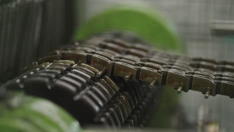 large heavy oiled chain on old machine operating in industrial factory - close up