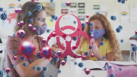Animation-of-biohazard-sign-covid-19-cells-over-female-teacher-and-schoolgirl-in-face-masks