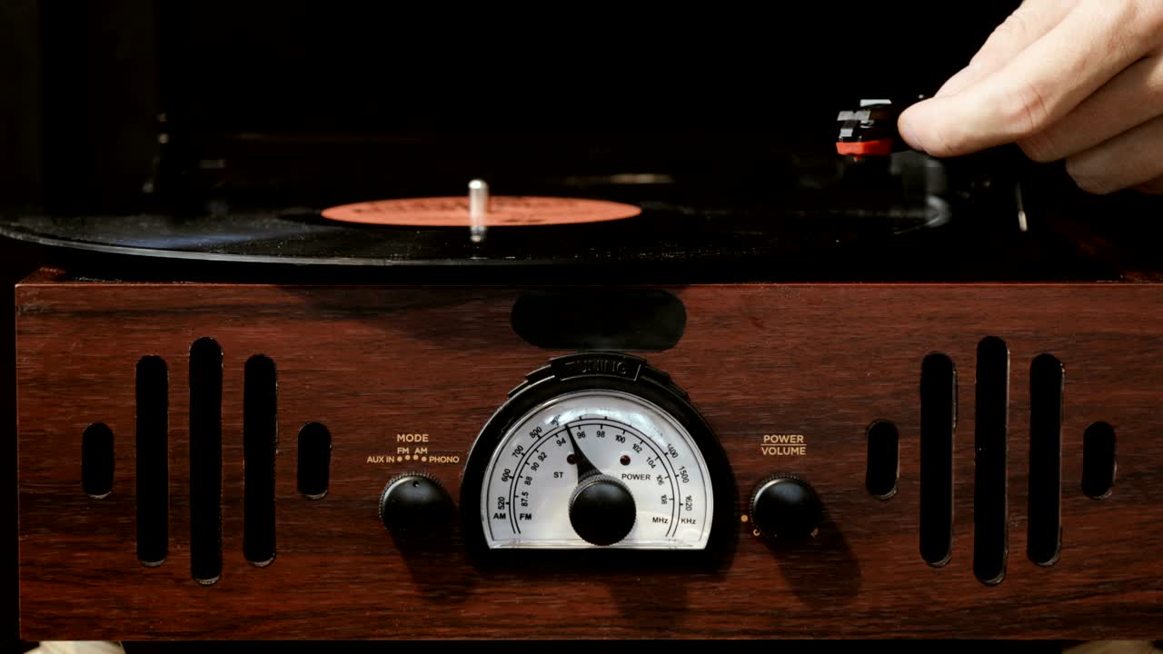 고대 비닐 레코드 플레이어를 사용하는 클로즈업. 턴테이블 플레이어, 비닐 레코드를 재생하는 스타일러스 바늘을 떨어뜨리는