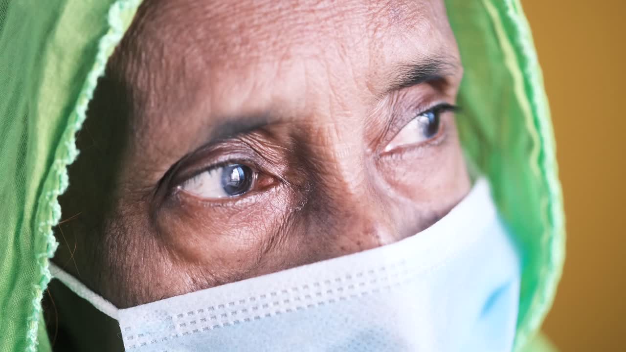 히자브와 마스크를 입은 노인 여성