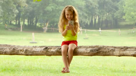 chica jugando con su teléfono inteligente en un parque