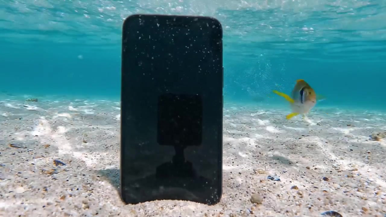 Esplorando l'ignoto: un telefono cellulare sommerso sott'acqua in un oceano cristallino, catturando la bellezza della tecnologia e della natura in armonia.