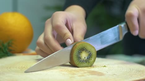 Zeitlupenhand-Einer-Frau,-Die-Kiwi-Schneidet