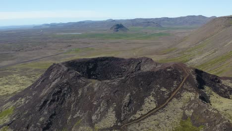 sobrevuelo aéreo del cráter del volcán y el paisaje pintoresco de la isla de islandia durante la luz del sol brillante y el cielo azul