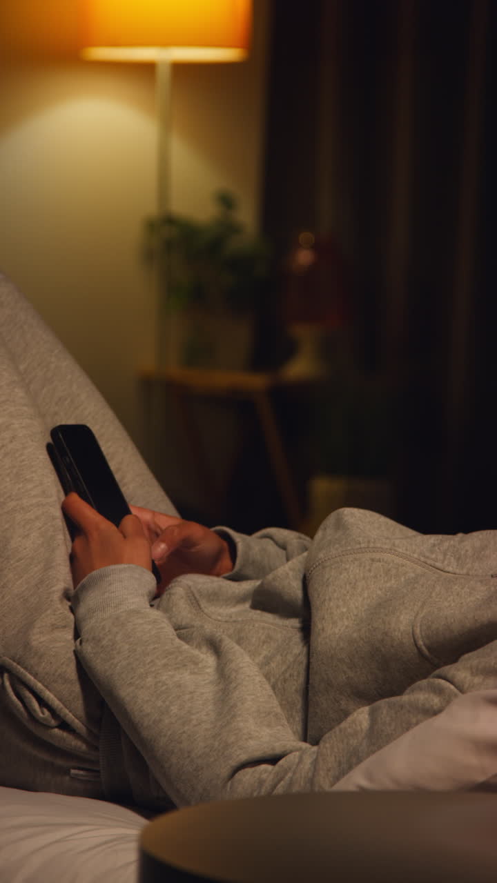 Person using phone in bed at night