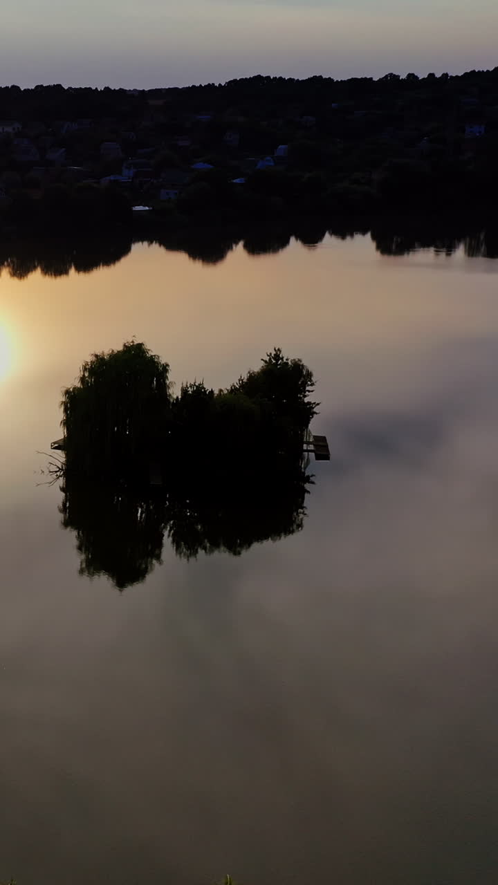 Reflection of sun in water. Aerial view of reflection of sunset in the water. Vertical video