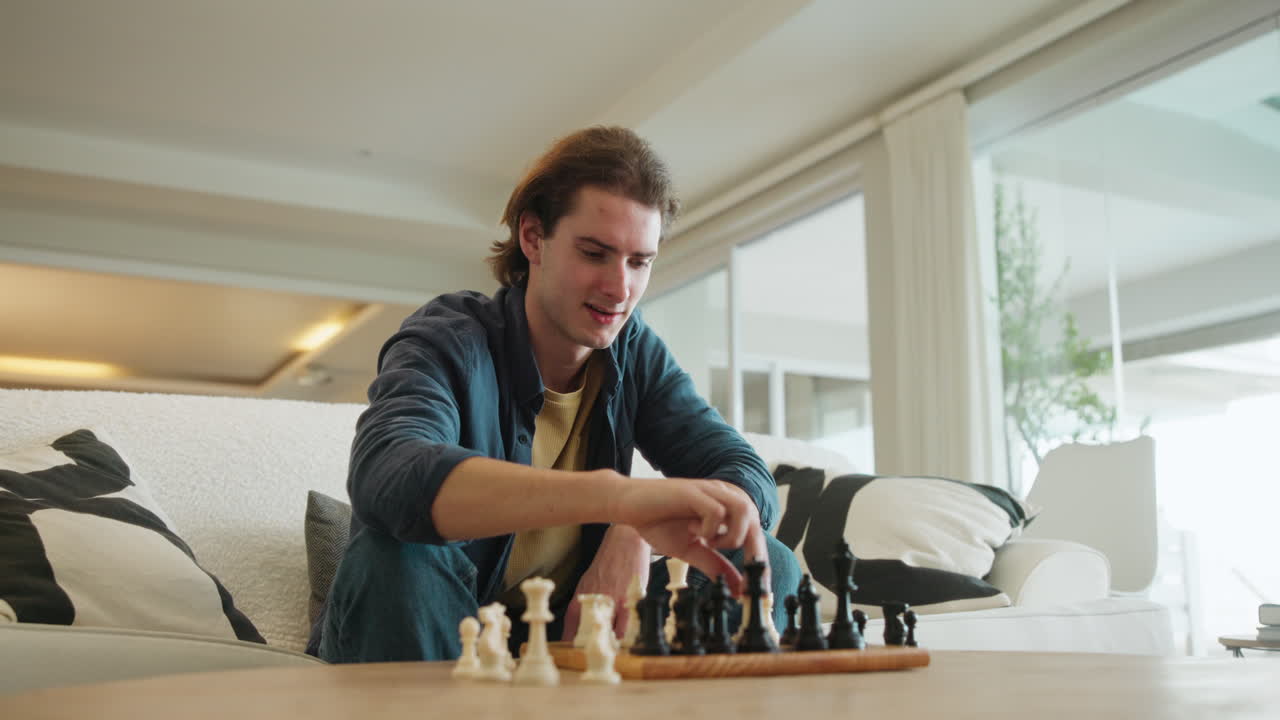 A man is playing chess indoors