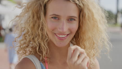 close up portrait of beautiful blonde woman running hand through hair smiling confident enjoying relaxed sunny day on summer vacation