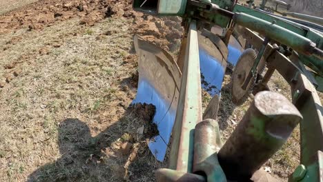 Close-up-of-plow-chisel-when-farmer-raises-the-plow-to-turn-into-a-new-row-in-the-field