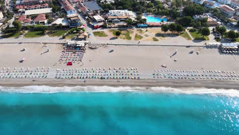 Disparo-Desde-Un-Dron-De-Un-Panorama-De-La-Línea-De-Playa-Con-Sombrillas-Y-Tumbonas-En-El-Mediterráneo-En-Turquía