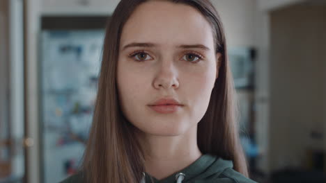 retrato de una hermosa adolescente en la cocina en casa buscando una expresión seria