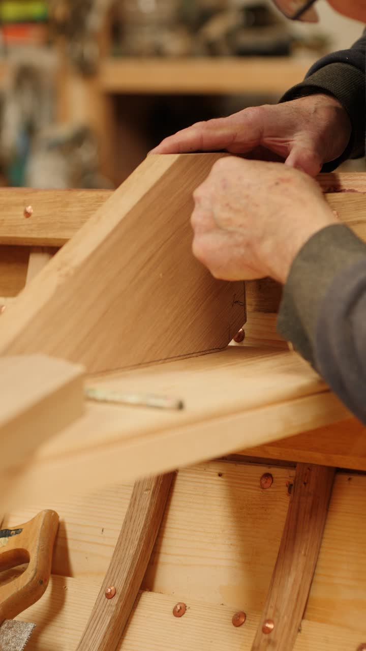 Boatbuilder markes oak knee to fit gunwale