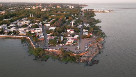 vista aérea del faro de la vieja ciudad de la colonia del sacramento con el resplandor del amanecer en el horizonte de uruguay