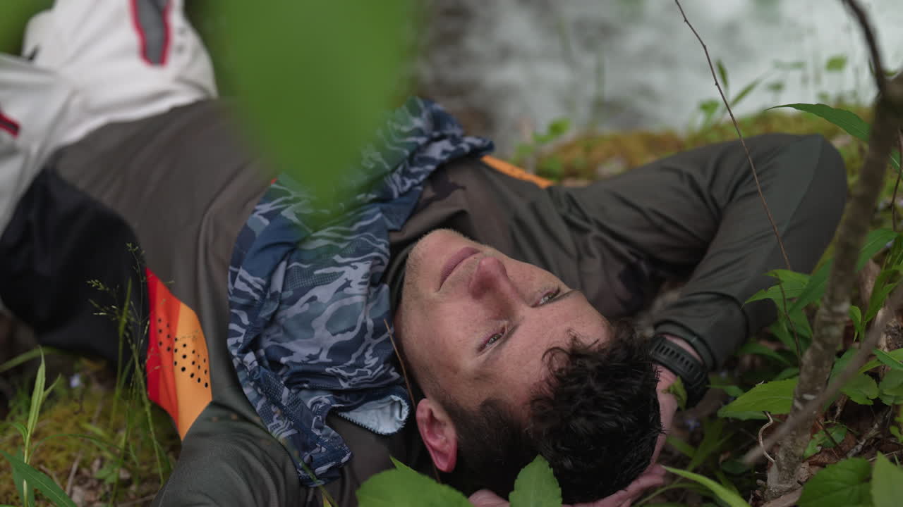 motociclista tomando un descanso a mitad de viaje en el sendero cerca de un arroyo de agua en la naturaleza, libertad, descanso, disfrute, contenido, pasatiempo, pasión, feliz