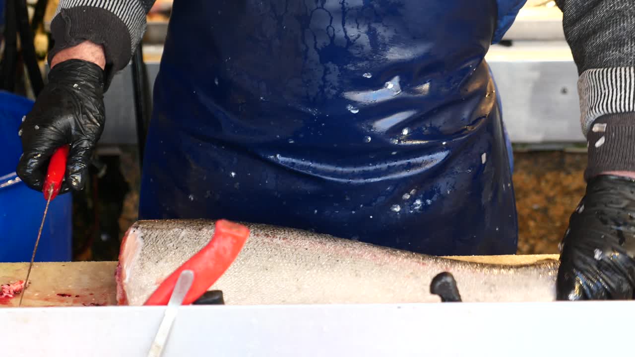 un pescador cortando un filete de salmón