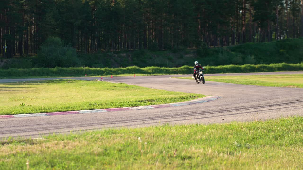 森の中のレーストラックを走るオートバイレーサー、モータースポーツシーン、ハンドヘルド撮影