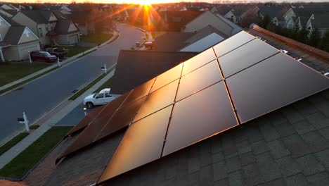 solar panels reflecting golden hour sunlight on shingle roof of modern home with renewable energy source