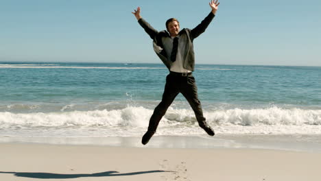 attractive businessman jumping on the beach