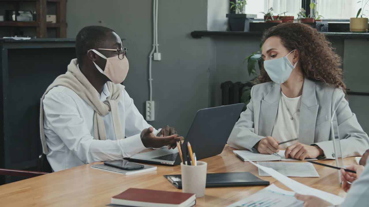 Multi-Ethnic Business Partners in Face Masks Negotiating