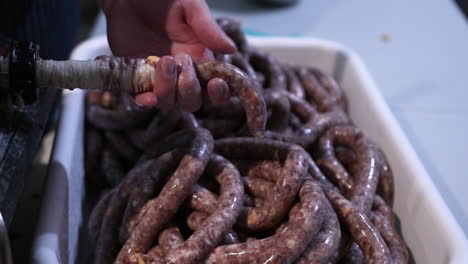 relleno de tripa de cerdo con mezcla de salchichas usando una máquina de relleno de salchichas - primer plano