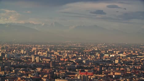 foggy mountain range and milan cityscape, view from above